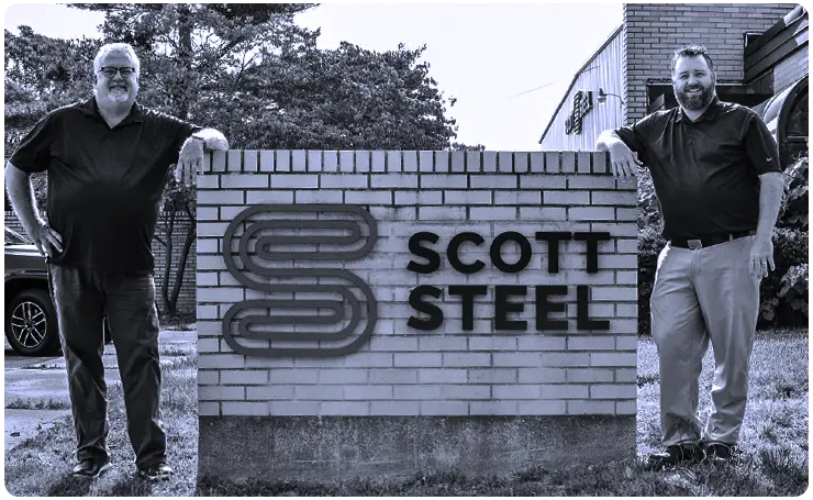 John Scott and Aaron Scott by the Scott Steel business sign